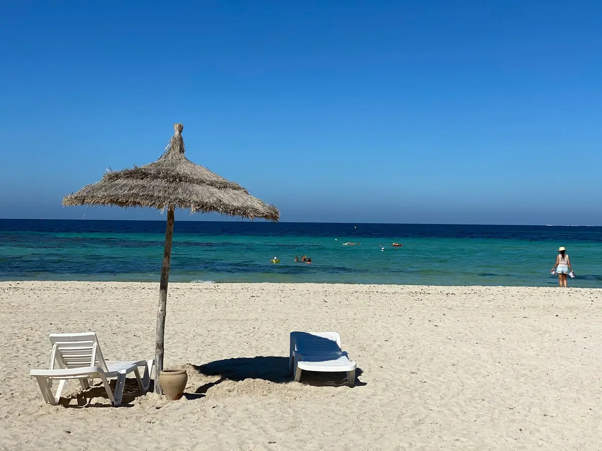 Parasole ze strzechy na piaszczystej plaży na Dżerbie