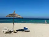 Parasole ze strzechy na piaszczystej plaży na Dżerbie