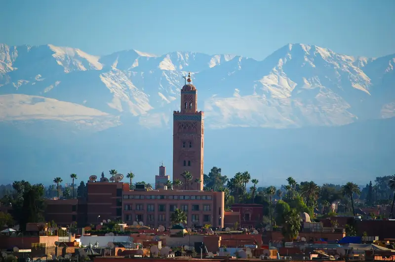Minaret Kutubijja w Marrakeszu na tle ośnieżonego Atlasu