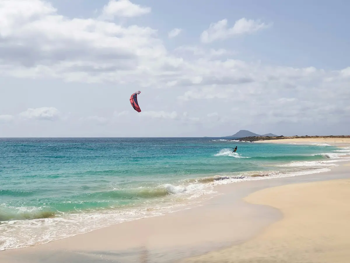 Kitesurfer na turkusowej wodzie przy plaży na wyspie Sal
