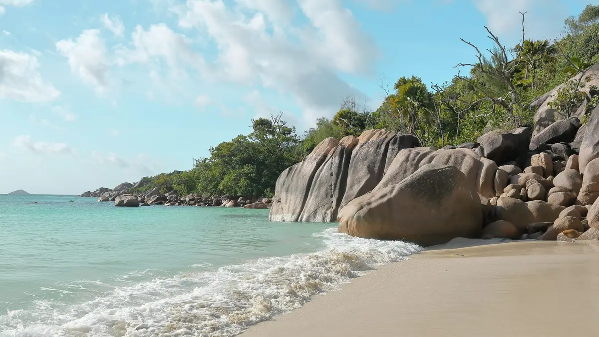 Granitowe głazy i fale na plaży Anse Lazio na Praslin