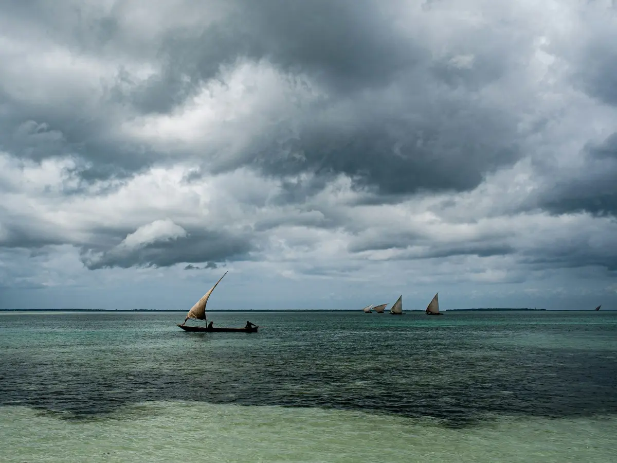 Łodzie dau pod burzowymi chmurami u wybrzeży Zanzibaru