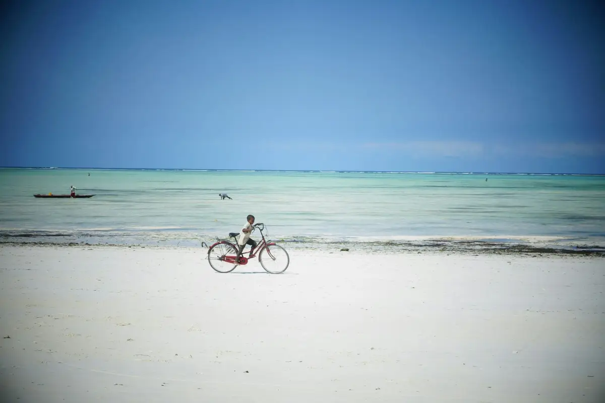Rowerzysta na szerokiej plaży w Paje podczas odpływu