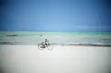 Rowerzysta na szerokiej plaży w Paje podczas odpływu